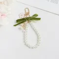 Detalle del llavero de lirio de los valles con cinta de terciopelo y cadena de perlas - Estilo Correa de Mano Perla con Lazo (5208-5)