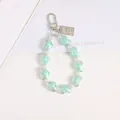 Detail of mint green heart resin beads and white pearls keychain with metal tag - Green