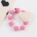 Dettaglio del braccialetto di peluche rosa con cuore e perle sintetiche eleganti - Rosa Rossa