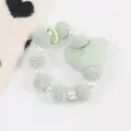 Dettaglio del bracciale in peluche verde chiaro con perle e ciondolo a cuore - Verde Menta