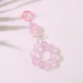 Makro-Detail eines rosa Schlüsselanhängers mit Kleeblatt, glitzernden Perlen und Anhängern - Traumhaftes Rosa