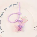 Detailed close-up of a pink jelly balloon dog keychain with purple spring strap and charms - Pink