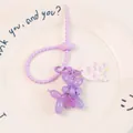 Détail d'un porte-clés chien ballon violet avec une sangle flexible et un petit charme - Violet