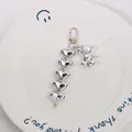 Close-up of silver bear keychain with five heart charms on a white ceramic plate - Silver (yc5239-2)