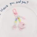 Detail of pink beaded moon keychain with star charms and acrylic heart on a white plate - Pink (yc5230-2)