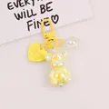 Detailed close-up of yellow glowing 3D bear keychain with holographic heart charm - Bright Yellow