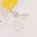 Detailed macro view of an iridescent acrylic flower keychain with leaf charm and round bead - White (yc5231-6)