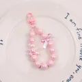Detail of pink pearlescent beaded keychain with bear charm and bow decoration - Pink