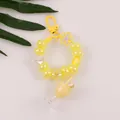 Detail of yellow beaded keychain with star, flower charm and milk tea bottle pendant - Yellow (R)