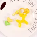 Detailed macro of yellow jelly balloon dog keychain with heart charms and matching bell - Yellow (yc5257)