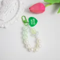 Dettaglio di ciondolo in perle con cuore verde e testo inciso For Ever inciso - Verde