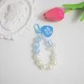 Dettaglio del ciondolo di perline azzurre con charm a tulipano e targhetta a cuore blu - Blu