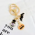 Detail eines Halloween Schlüsselanhängers mit Emaille-Totenkopf, Fledermaus und Kürbis - Orange