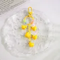 Detail of yellow duck keychain with five resin charms and colorful smiley beads - Yellow