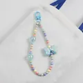 Detail of colorful macaron bead bag charm with a blue bow on a white canvas bag - Blue