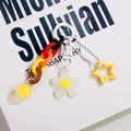 Detail of flower keychain with acrylic star, colorful links, and white matte floral charm - White