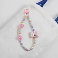 Close-up of colorful beaded bag charm with pink polka dot bow on white canvas bag - Pink
