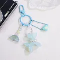 Detail of light blue balloon dog keychain with rainbow and heart charms on textured base - Blue
