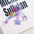 Detail of a purple acrylic keychain with colorful chain links and floral star charms - Purple