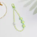 Detalle de un llavero de flores con perlas blancas y colgantes florales verdes - Verde