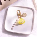 Dettaglio portachiavi a conchiglia gialla con perle bianche e gancio dorato - Giallo