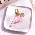 Detailed view of pink shell keychain with pearl tassel on a decorative ceramic tray - Rose Red