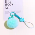 Detail of mint green plush ball keychain with marble heart bead and blue bell charm - Lake Blue