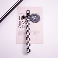 Close-up of checkered ribbon keychain with black daisy charm and matte metal clip - White Calla Lily (yc5305-5)