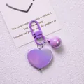 Detail of a purple heart-shaped keychain with iridescent finish and matching lobster clasp - Purple