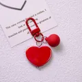 Detail of red heart keychain with matching matte bead and metallic clasp on white card - Red