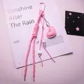 Detail eines rosa Lederherz-Anhängers mit geflochtenem Seil und Perlen am Taschenhalter - Rosa
