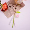 Schlüsselanhänger mit rosa Harzrose und bunten Perlen an goldfarbenem Karabinerhaken - Rosa