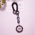 Macro view of vintage poker chip keychain with black spiral cord and acrylic chain links - Black (Value 100)