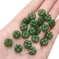 Dark green four-leaf clover glass bead held in hand for DIY jewelry making - Synthetic Dark Green Jade