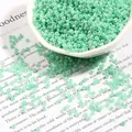 2mm mint green glass seed beads for DIY jewelry making in a white porcelain bowl - Peacock Green