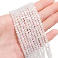 Hand holding white cat eye stone round beads with shimmering finish for DIY jewelry - 4mm White (1 Strand/Pack, approx. 95 Beads)
