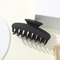 Vista macro de una pinza para el cabello negra mate grande con diseño de múltiples dientes - Negro