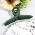 Detail view of large dark green matte claw clip with cross twist design and strong grip teeth - Green