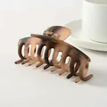 Detail of a matte tortoiseshell hair claw clip with a strong metal spring and gradient texture - Brown