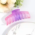 Detailed view of large pink-purple gradient hair claw clip on marble tray with flowers - Purple