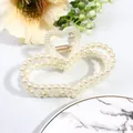 Detailed close-up of a heart-shaped pearl hair claw clip on a minimalist white background - Heart