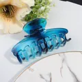 Detail of blue gradient hair claw clip with glossy finish on a decorative marble plate - Blue