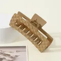 Detail of a large khaki rectangular hair claw clip with a matte quilted pattern texture - Light Coffee