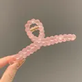 Macro view of matte pink bubble bead hair claw clip with golden metal spring - Frosted Orange
