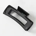 Macro shot of rectangular hollow hair claw clip in glossy black resin finish - Black