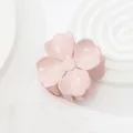 Nahaufnahme einer hellrosa Haarspange in Blumenform auf weißem minimalistischem Grund - Hellrosa
