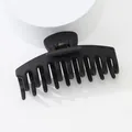 Close-up of matte black hair claw clip featuring non-slip teeth and metal spring detail - Black