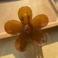 Macro view of a translucent amber flower hair claw clip with a glossy resin finish - Light Coffee