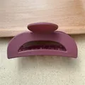 Dettaglio molletta per capelli opaca color malva con denti forti su vassoio legno - Borgogna