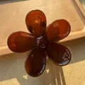 Macro detail of a translucent amber resin five-petal flower hair claw clip with glossy finish - Dark Coffee